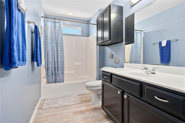 bathroom with baseboards, toilet, wood finished floors, shower / bathtub combination with curtain, and vanity