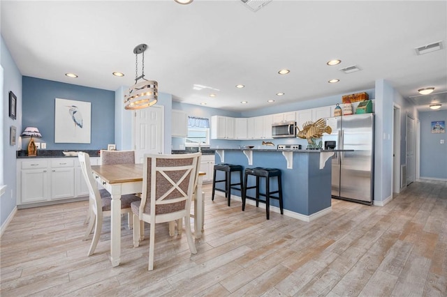 dining area with recessed lighting, visible vents, and light wood-style flooring