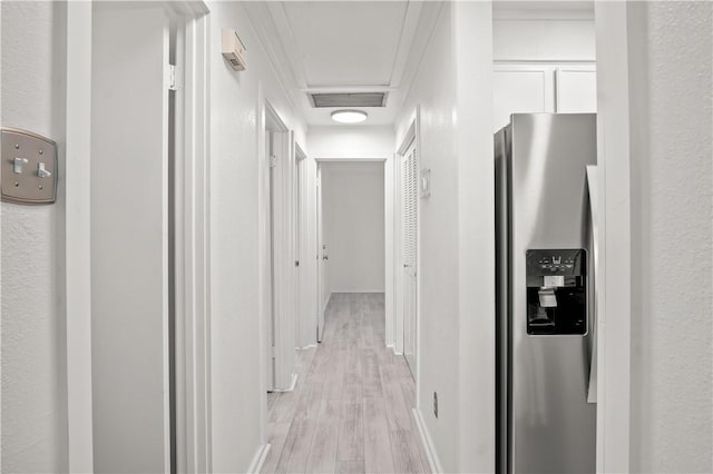 corridor with ornamental molding and light wood-type flooring