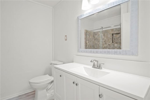 bathroom with toilet, wood-type flooring, walk in shower, and vanity