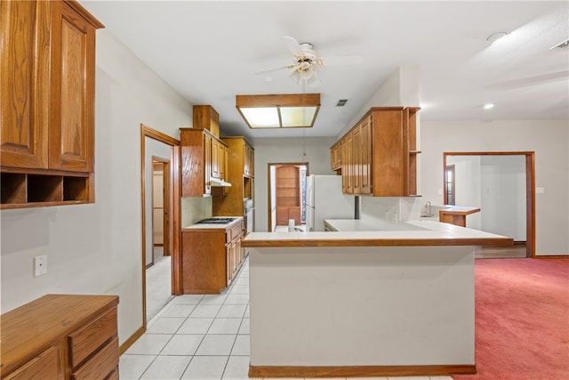 7205 Pharaoh Dr, Corpus Christi, TX 78412 - kitchen with ceiling fan, freestanding refrigerator, a peninsula, and light colored carpet