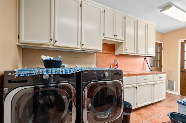 clothes washing area with cabinet space, independent washer and dryer, and light tile patterned floors