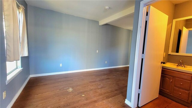 interior space with beam ceiling, hardwood / wood-style floors, and sink