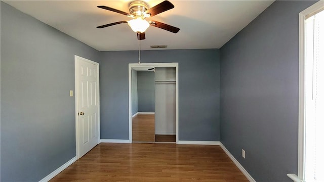 unfurnished bedroom with hardwood / wood-style floors, ceiling fan, and a closet