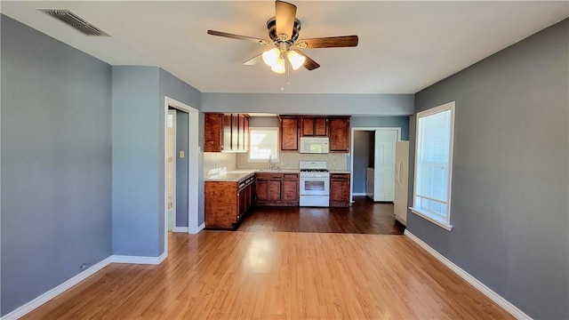 kitchen with hardwood / wood-style floors, white appliances, ceiling fan, and sink