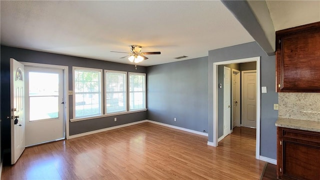 unfurnished living room with ceiling fan and light hardwood / wood-style flooring