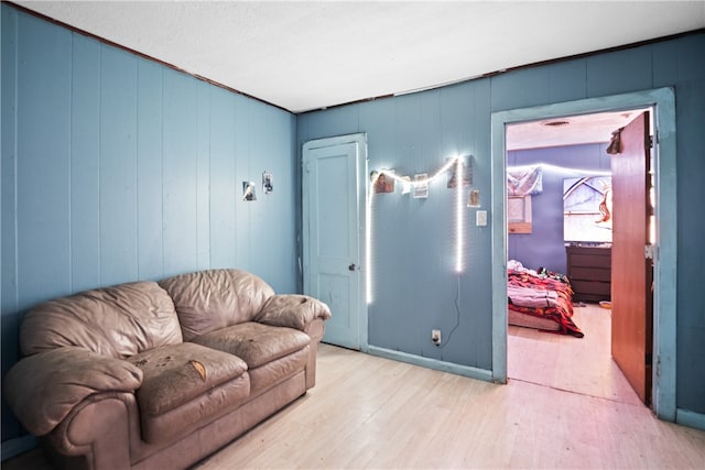 living room with light hardwood / wood-style floors and wood walls