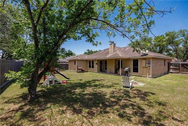 14605 Reagan Dr, Corpus Christi, TX 78410 - back of property featuring a chimney, a playground, and a patio