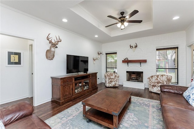 14605 Reagan Dr, Corpus Christi, TX 78410 - living area featuring a raised ceiling, ornamental molding, ceiling fan, wood finished floors, and a brick fireplace