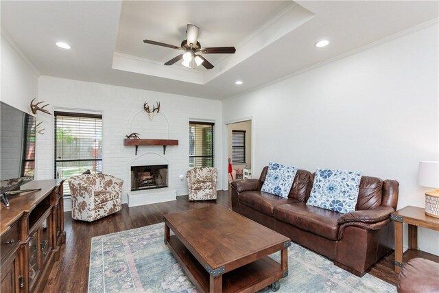 14605 Reagan Dr, Corpus Christi, TX 78410 - living room with a raised ceiling, ceiling fan, a fireplace, dark wood-style flooring, and ornamental molding