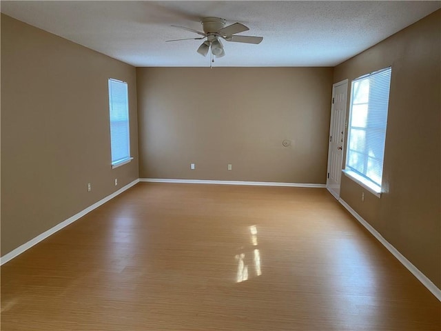 unfurnished room with ceiling fan, a textured ceiling, and light hardwood / wood-style floors