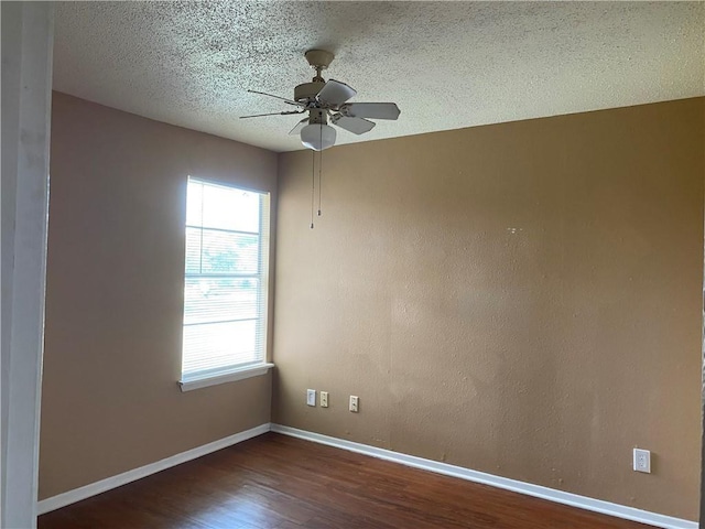 empty room featuring dark hardwood / wood-style flooring, a textured ceiling, and ceiling fan