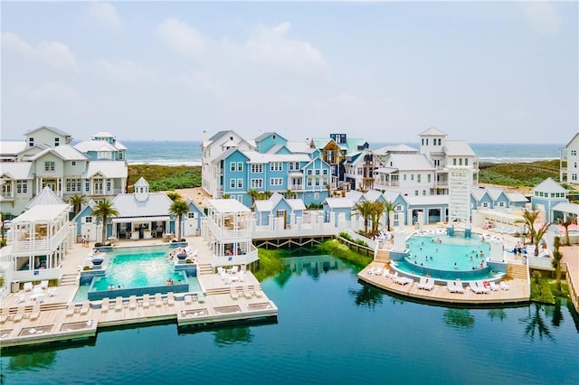 back of house with a water view and a community pool