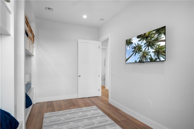 bedroom with recessed lighting, wood finished floors, visible vents, and baseboards