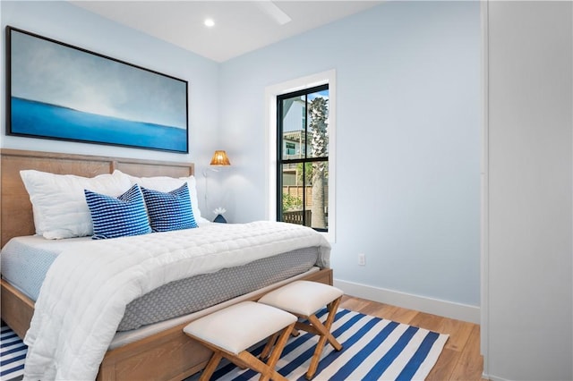 bedroom with baseboards, wood finished floors, and recessed lighting