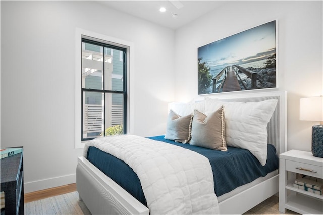 bedroom with recessed lighting, wood finished floors, and baseboards