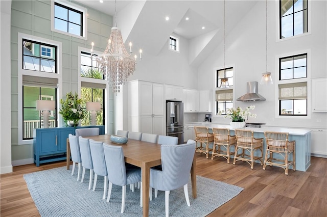 dining area featuring a healthy amount of sunlight, light wood-style floors, baseboards, and a notable chandelier