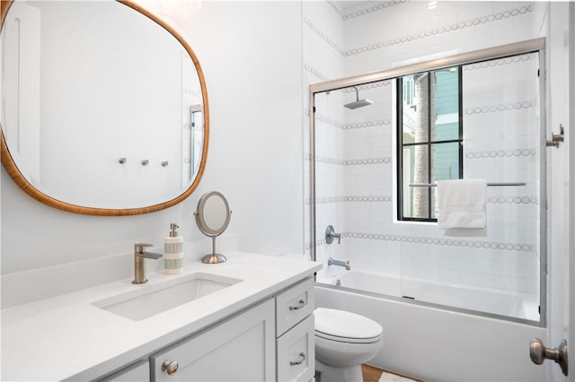 full bath featuring combined bath / shower with glass door, vanity, and toilet