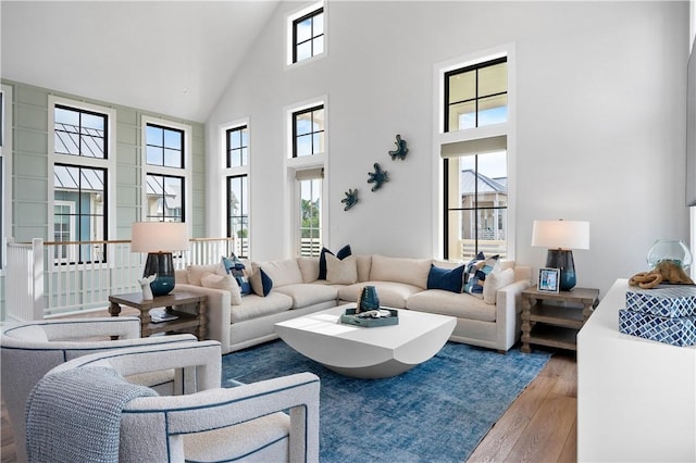 living area with wood-type flooring and high vaulted ceiling