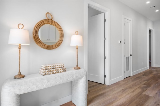 hall with baseboards, visible vents, wood finished floors, and recessed lighting