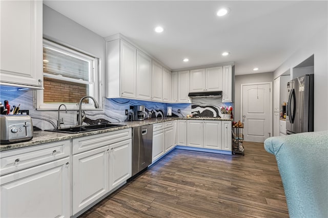 kitchen featuring dark wood-type flooring, white cabinetry, appliances with stainless steel finishes, and backsplash