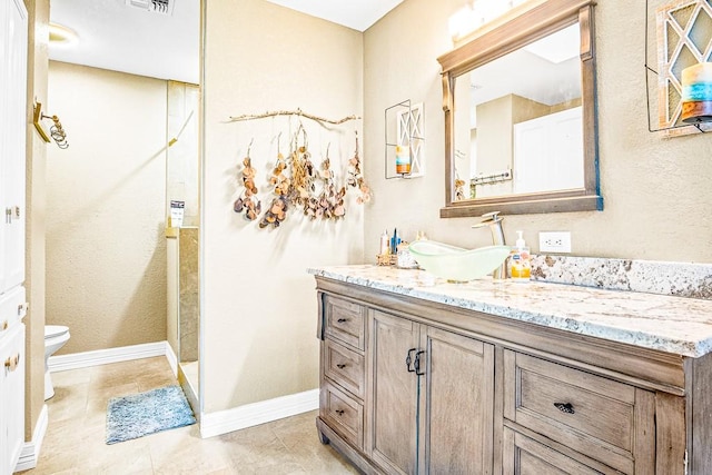 bathroom with toilet, tile patterned flooring, and vanity