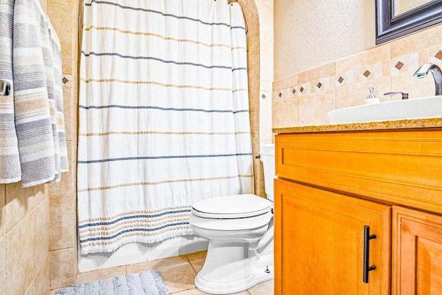 bathroom with vanity, toilet, curtained shower, and tile walls