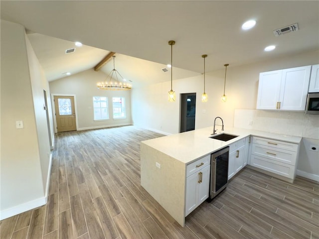 kitchen with white cabinetry, sink, and wine cooler