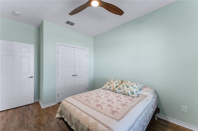 bedroom featuring a closet, visible vents, ceiling fan, wood finished floors, and baseboards