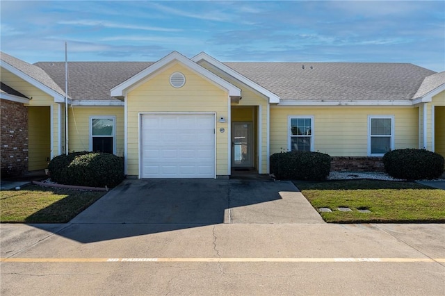 ranch-style home featuring an attached garage, driveway, a shingled roof, and brick siding