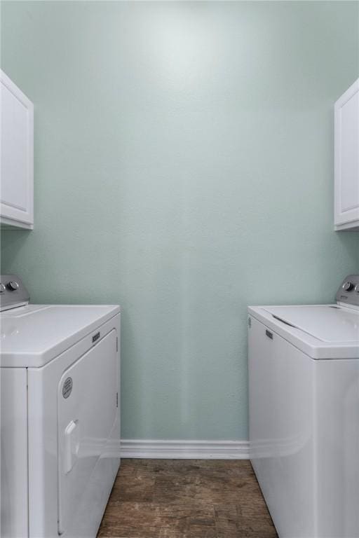 clothes washing area featuring wood finished floors, cabinet space, baseboards, and separate washer and dryer