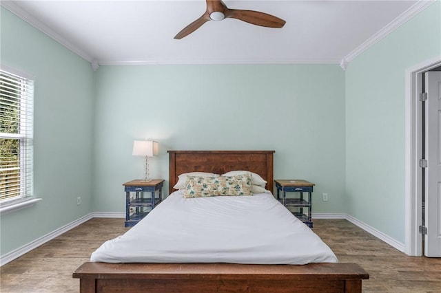 bedroom with ornamental molding, wood finished floors, and baseboards