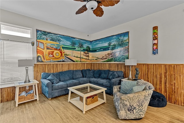 living room featuring wood walls, hardwood / wood-style flooring, and ceiling fan