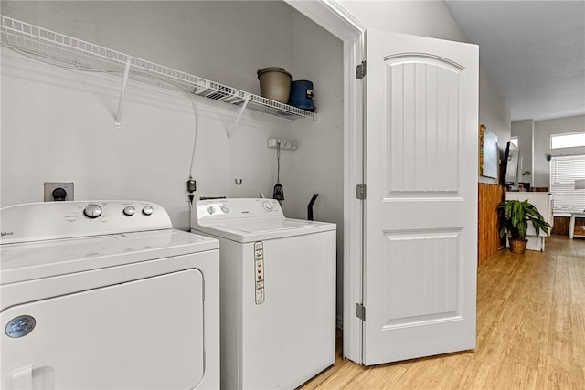 clothes washing area featuring light wood-type flooring and independent washer and dryer