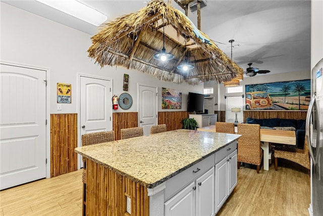 kitchen with a center island, ceiling fan, light hardwood / wood-style floors, and white cabinets