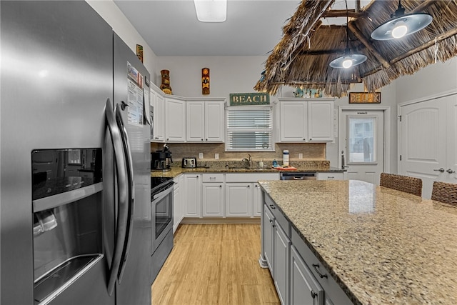 kitchen featuring white cabinetry, stainless steel appliances, and light hardwood / wood-style flooring