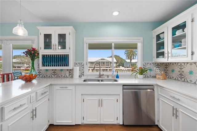 kitchen with dishwasher, light countertops, a sink, and white cabinets