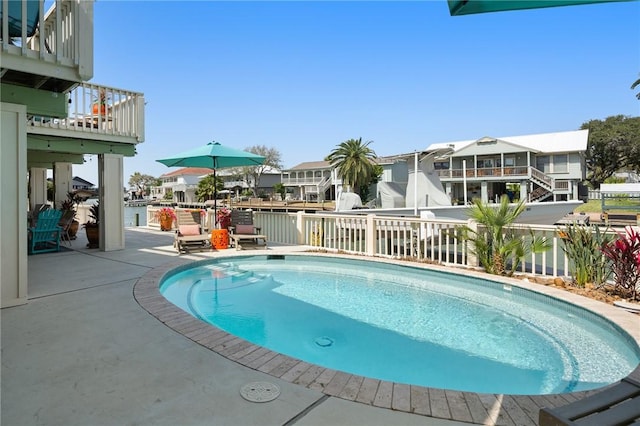 view of swimming pool featuring a patio area, a residential view, and a fenced in pool