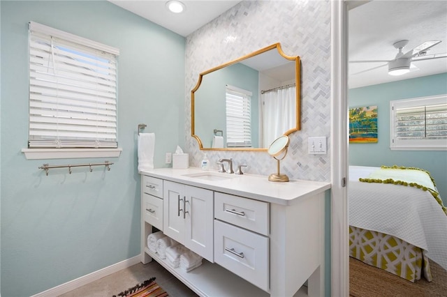 bathroom featuring plenty of natural light, baseboards, a ceiling fan, and vanity