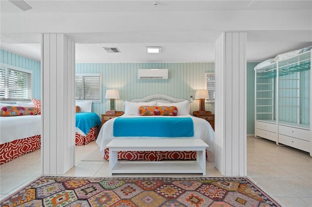 bedroom featuring tile patterned flooring, visible vents, and a wall mounted AC