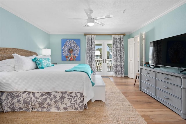 bedroom featuring a textured ceiling, light wood-style flooring, access to exterior, french doors, and ornamental molding