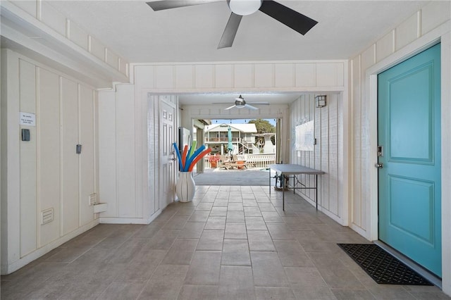 foyer entrance featuring ceiling fan and a decorative wall