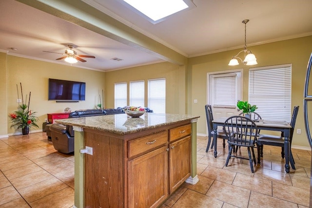 7009 Tocken Ct, Corpus Christi, TX 78414 - kitchen featuring crown molding, a kitchen island, light tile patterned floors, pendant lighting, and a chandelier