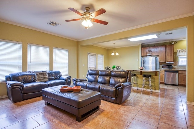7009 Tocken Ct, Corpus Christi, TX 78414 - living room with light tile patterned floors, a ceiling fan, crown molding, and a chandelier