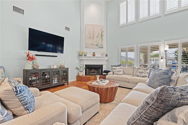 107 Angelfish, Aransas Pass, TX 78336 - tiled living room with a towering ceiling, plenty of natural light, and a fireplace with raised hearth