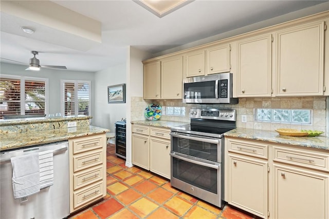 107 Angelfish, Aransas Pass, TX 78336 - kitchen featuring stainless steel appliances, cream cabinets, tasteful backsplash, a ceiling fan, and wine cooler