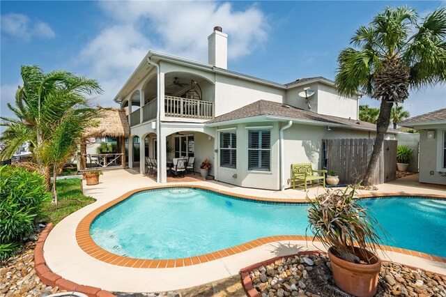 107 Angelfish, Aransas Pass, TX 78336 - back of property featuring a balcony, stucco siding, a patio area, a ceiling fan, and an outdoor pool