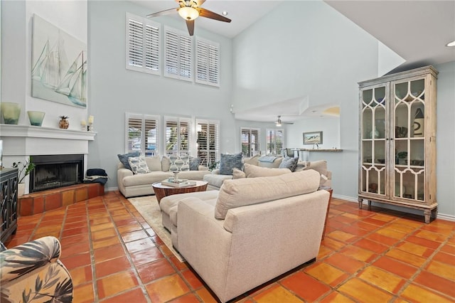107 Angelfish, Aransas Pass, TX 78336 - tiled living room featuring a ceiling fan, a towering ceiling, a fireplace with raised hearth, and recessed lighting