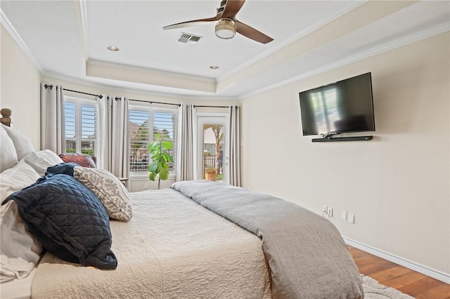 107 Angelfish, Aransas Pass, TX 78336 - bedroom featuring wood finished floors, a tray ceiling, ornamental molding, and a ceiling fan