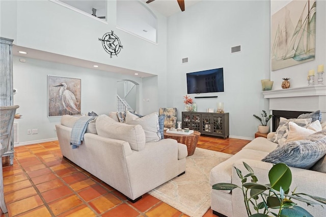 107 Angelfish, Aransas Pass, TX 78336 - living room featuring a fireplace, a towering ceiling, tile patterned floors, arched walkways, and ceiling fan